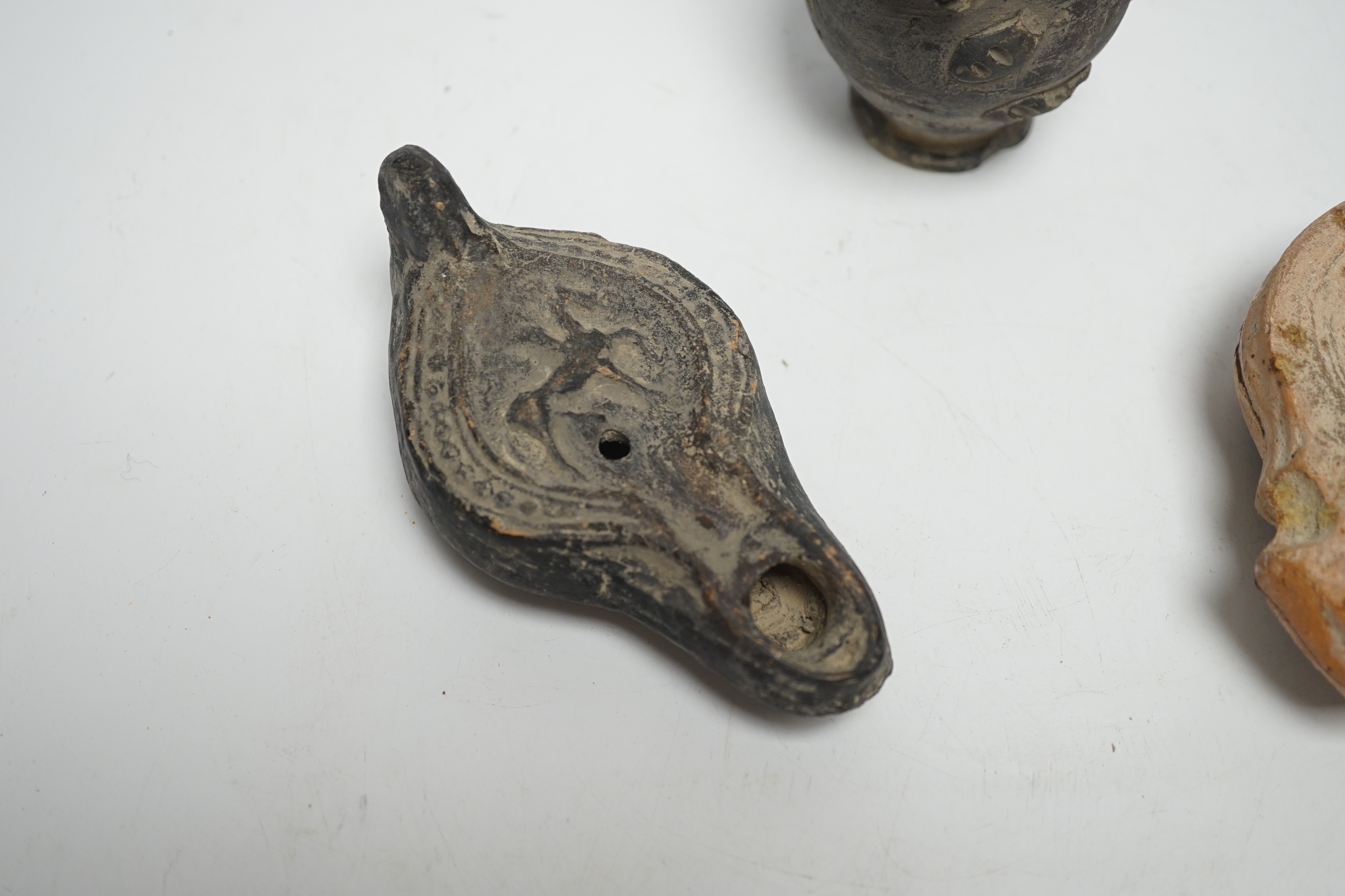 Two Roman oil lamps and an early ewer, tallest 14.5cm